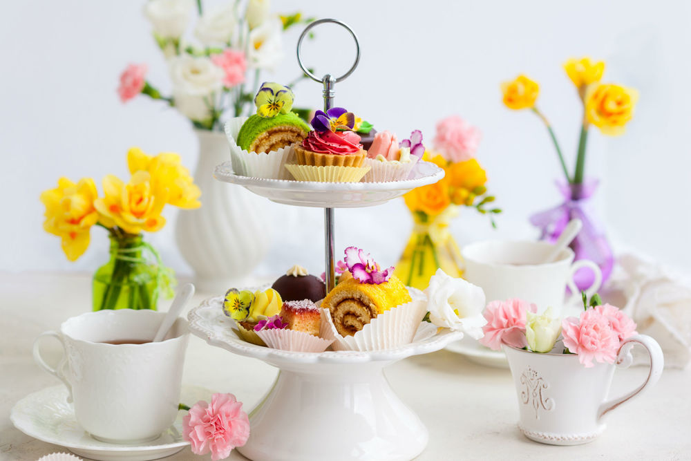 Обои для рабочего стола Сервировка к чаепитию с цветами и сладостями на подставке