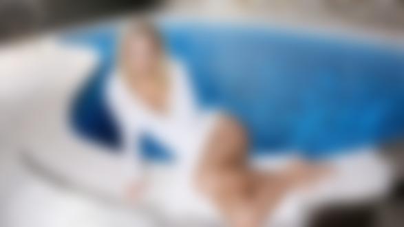 Обои для рабочего стола Девушка в кофточке с декольте и обнаженными ножками сидит у бассейна