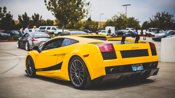 Обои на рабочий стол Желтый Lamborghini Aventador стоит на парковке