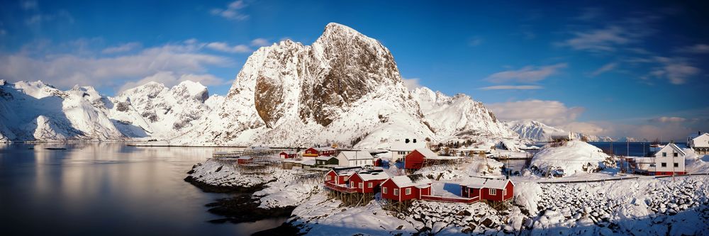 Обои для рабочего стола Небольшой островной поселок на фоне заснеженных гор и синего неба, Лофотенские острова / Lofoten islands, Рейне, Норвегия / Reine, Norway