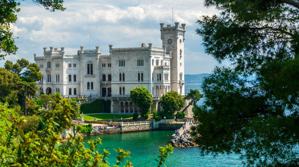 Обои для рабочего стола Белый замок Miramare Castle / Мирамаре возле озера, в зеленой листве
