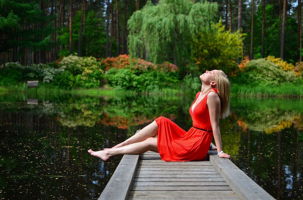 Обои для рабочего стола Девушка в красном платье сидит на мостике у водоема, by Zigmars Berzins - moozthemes