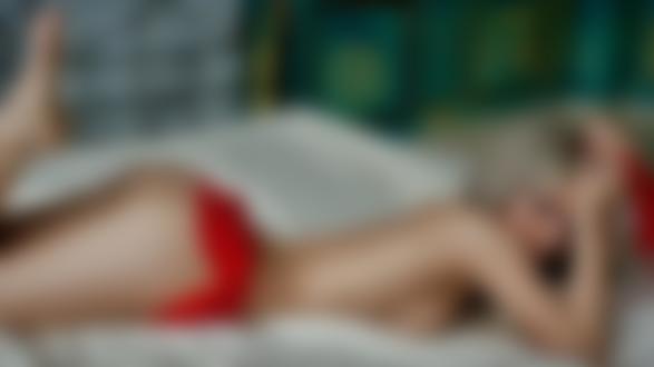 Обои для рабочего стола Симпатичная блондинка позирует, лежа на кровати