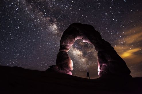 Обои на рабочий стол Мужчина стоит в проеме Delicate Arch, Utah, USA / Изящной Арки, штат Юта, США, на фоне млечного пути в звездном небе, by skeeze