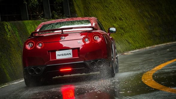 Обои на рабочий стол Красный Nissan GT-R на мокрой дороге