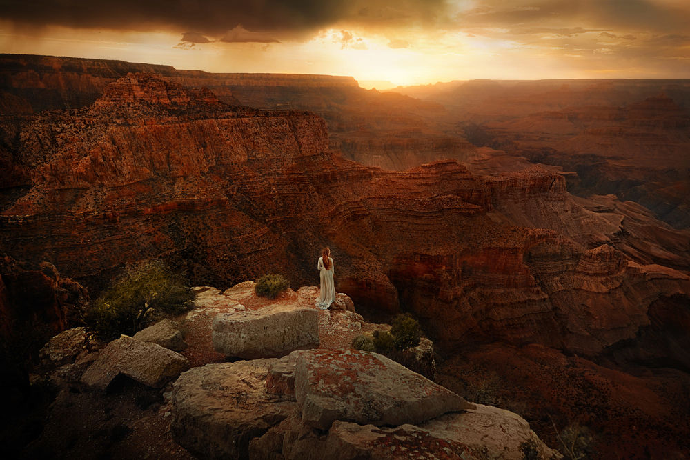 Обои для рабочего стола Девушка в длинном платье стоит на фоне Grand Canyon / Гранд-Каньона, фотограф TJ Drysdale