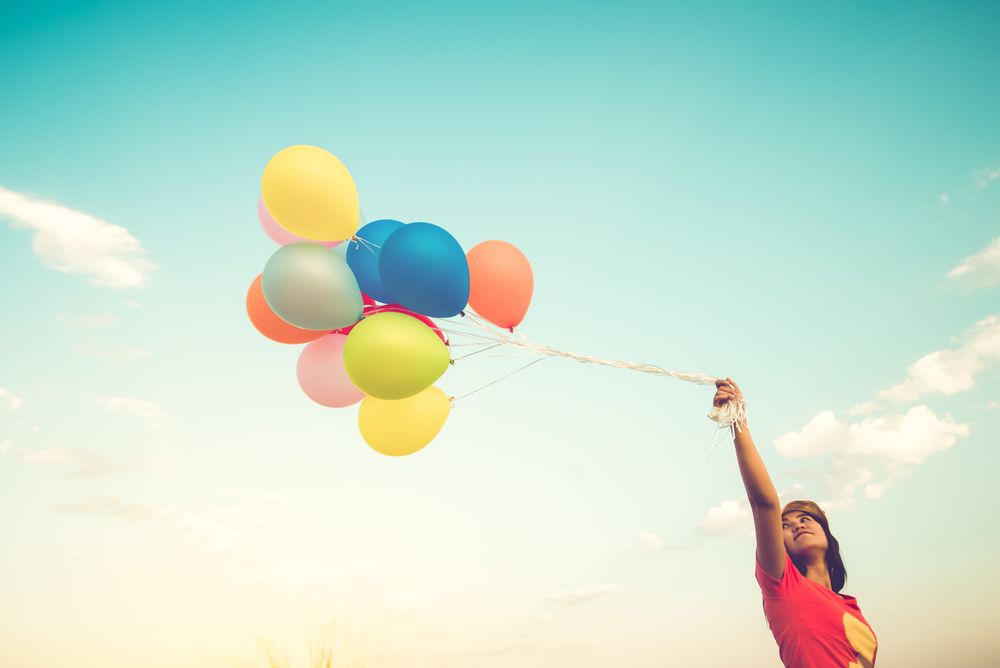 Обои для рабочего стола Девушка с воздушными шариками на фоне неба