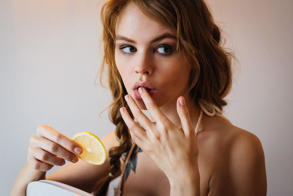 Обои для рабочего стола Анастасия Щеглова с долькой лимона в руке. Фотограф Лиза Шабурова