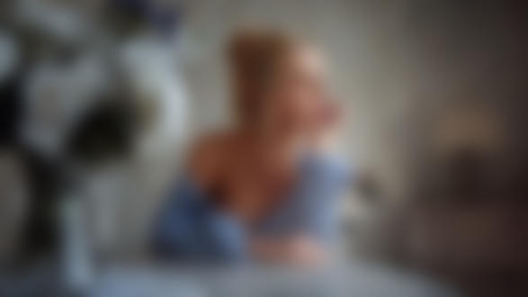 Обои на рабочий стол Модель Маша сидит за столом, на котором стоят цветы в кувшине. Фотограф Георгий Чернядьев