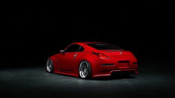 Обои на рабочий стол Красный Nissan 350 Z стоит в темноте