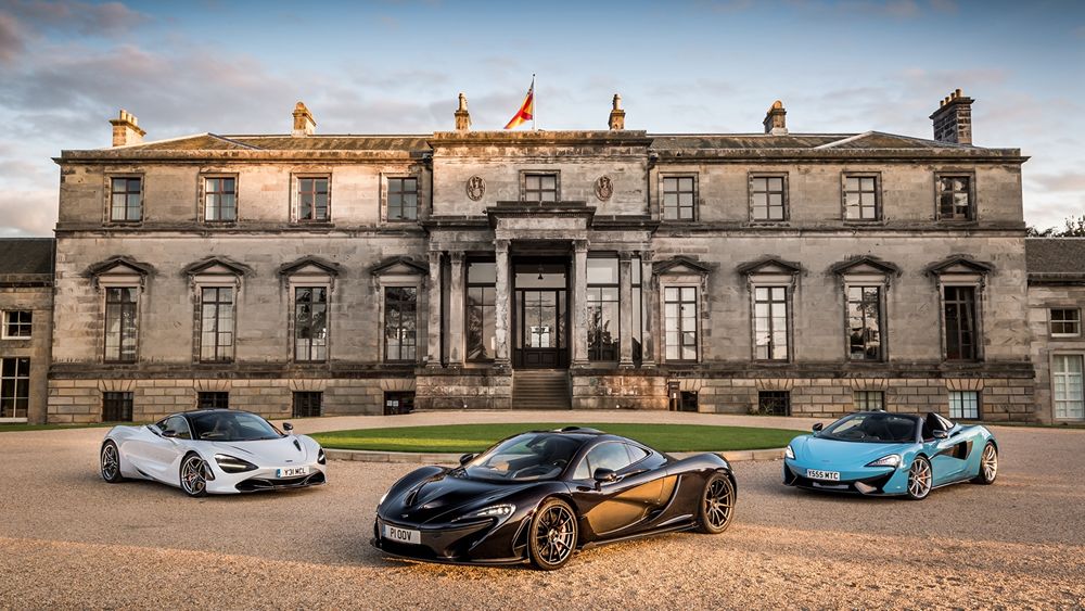 Обои для рабочего стола Три авто марки McLaren / Макларен стоят перед двухэтажным зданием