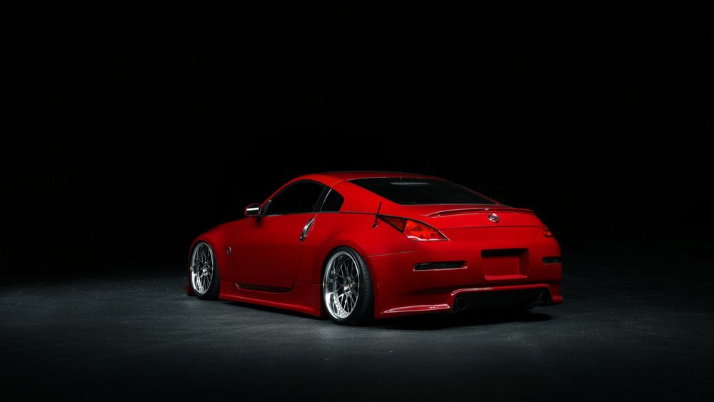 Обои для рабочего стола Красный Nissan 350 Z стоит в темноте