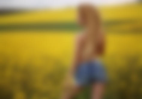 Обои для рабочего стола Модель мисс Марципанка в джинсовых шортах стоит на цветочном поле. Фотограф Ника Мельн