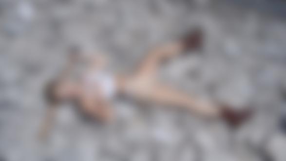 Обои для рабочего стола Певица Miley Cyrus / Майли Сайрус с молотком лежит на камнях