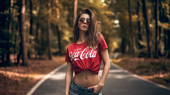 Обои на рабочий стол Модель Sara Tessitore в очках и футболке с надписью coca-cola стоит на дороге. Фотограф Martin Kuhn
