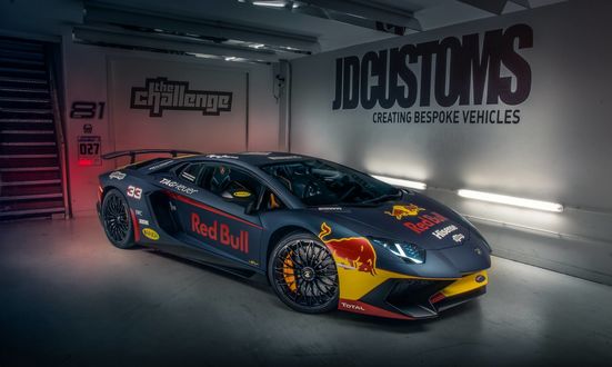Обои на рабочий стол Гоночный Lamborghini Aventador с рекламой Red Bull стоит в гараже