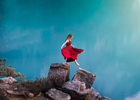 Обои на рабочий стол Девушка в красном платье шагает по камням, фотограф Lizzy Gadd