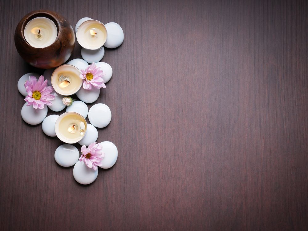 Обои для рабочего стола Spa-набор: зажженные свечи, белые камешки и розовые цветы на деревянной поверхности
