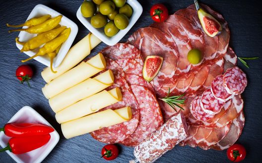 Обои на рабочий стол Разнообразие мясной и колбасной нарезки, помидоры - черри, оливки, красный и желтый перчик, и ломтики сыра