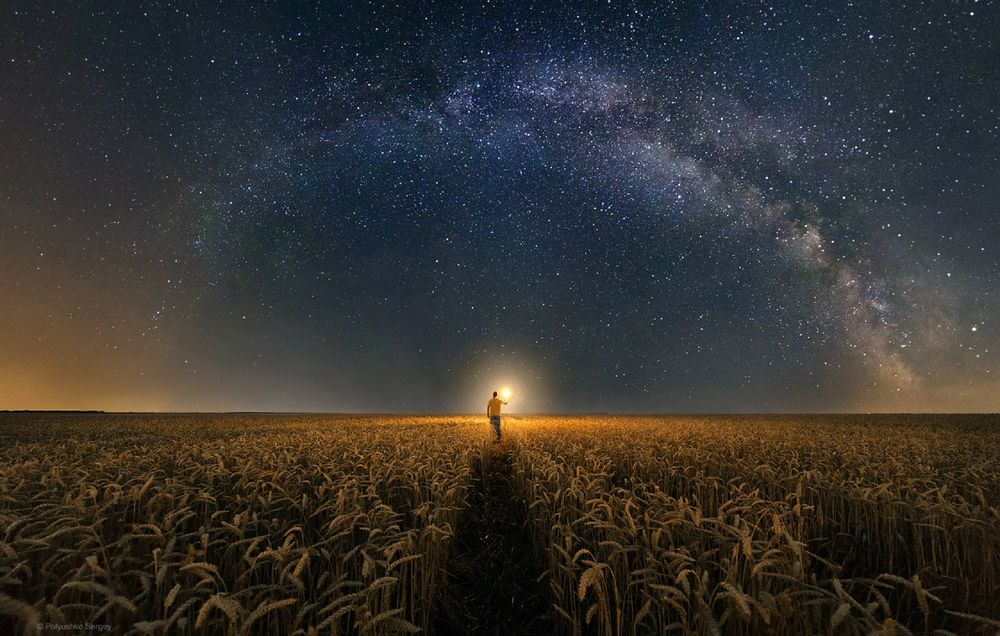Обои для рабочего стола Мужчина идет по пшеничному полю со свечой в руке на фоне млечного пути в ночном небе, фотограф Полюшко Сергей