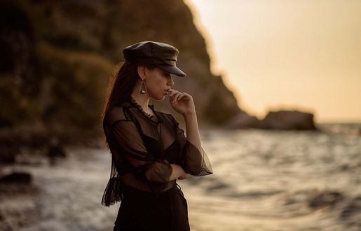 Обои на рабочий стол Модель DiLara Kirmit в фуражке стоит на фоне моря, фотограф Нуреттин Йылдырым