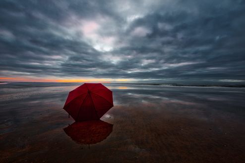 Обои на рабочий стол Красный зонт на побережье. Фотограф Peter Dekker