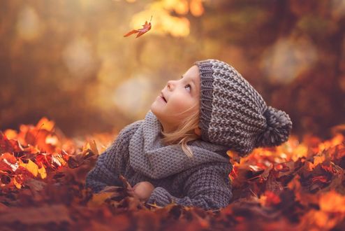 Обои на рабочий стол Девочка лежит на листве и смотрит на падающий листик, by Ania Kulinski Photography