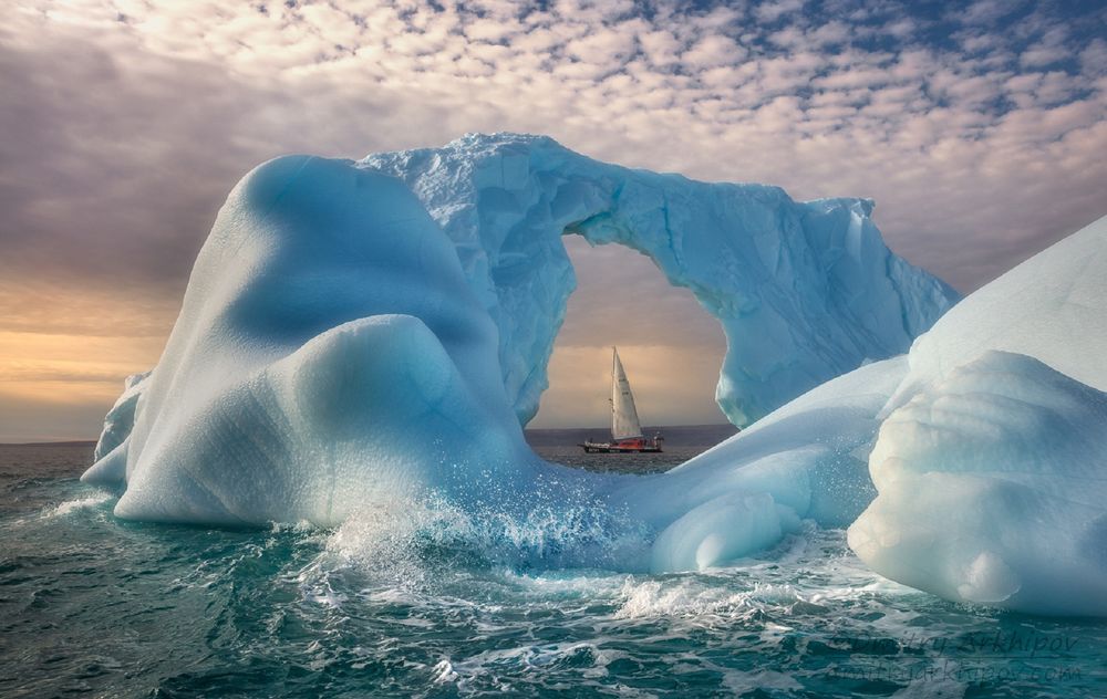 Обои для рабочего стола Парусник в ледяной арке айсберга, фотограф Дмитрий Архипов