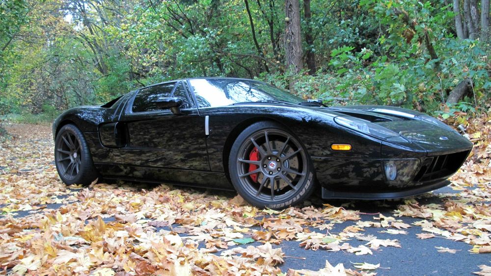 Обои для рабочего стола Черный Ford GT на дороге усыпанной листьями