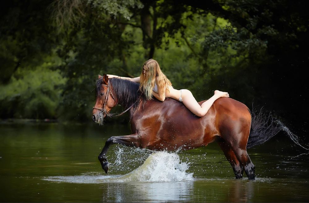 Обои для рабочего стола Модель Алена Сарафанова в купальнике верхом на лошади, бьющей копытом по воде, фотограф Михаил Семенов