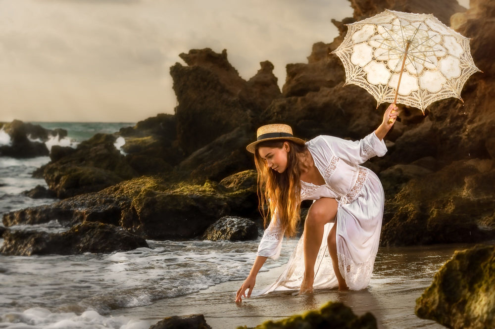 Обои для рабочего стола Девушка в шляпке, с зонтом в руке наклонилась к воде. Фотограф Alex Darash