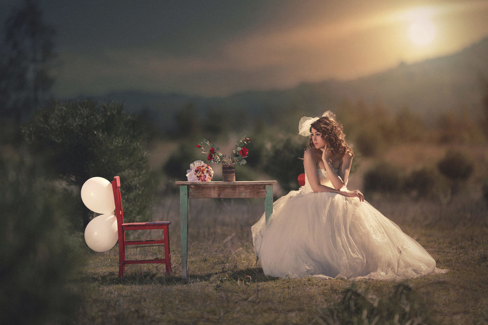 Обои для рабочего стола Девушка в свадебном платье сидит за столиком со стулом, на котором воздушные шары. Фотограф Durdali Dalgin