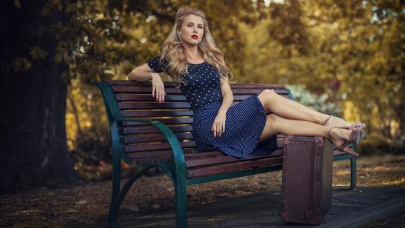 Блондинка сидит на скамейке