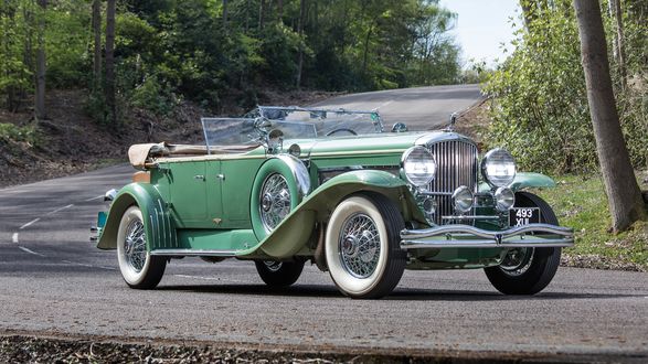 Обои на рабочий стол Ретро автомобиль Duesenberg J451 / 2468 Tourster LWB by Derham 1931 года стоит на дороге в лесу