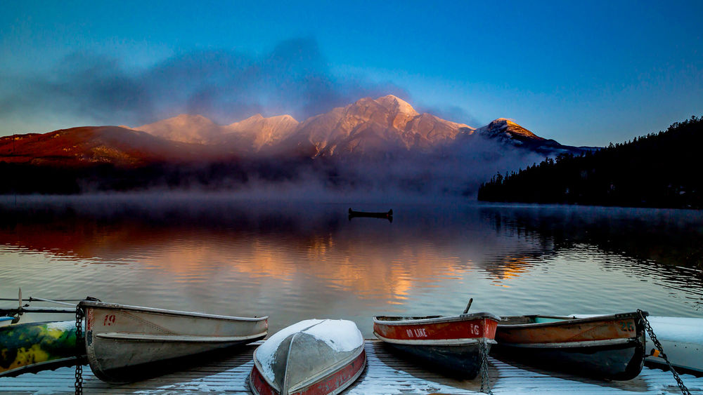 Обои для рабочего стола Лодки на озере и вдалеке гора под облаками