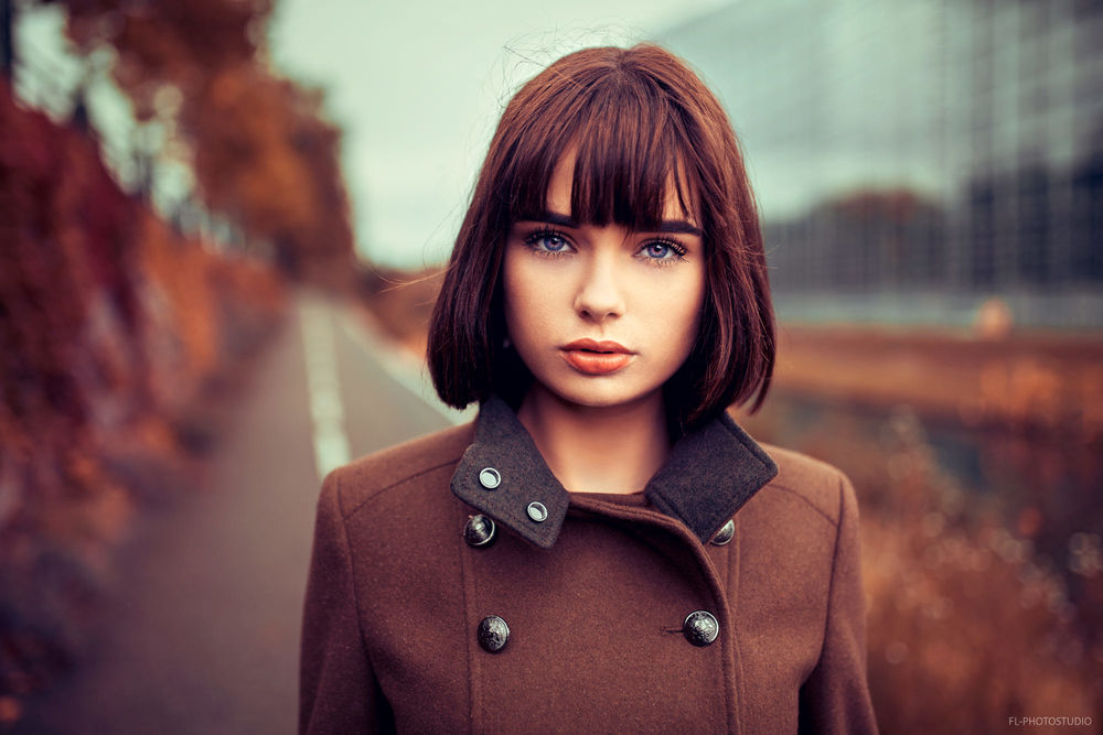 Обои для рабочего стола Модель Мария в пальто стоит на фоне города, фотограф Lods Franck