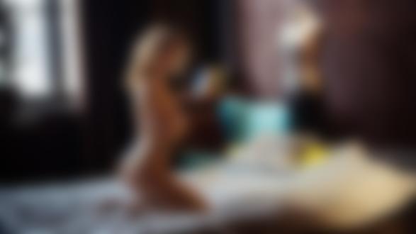 Обои для рабочего стола Обнаженная модель Анастасия позирует, стоя на коленях на кровати в комнате. Фотограф Максим Чуприн