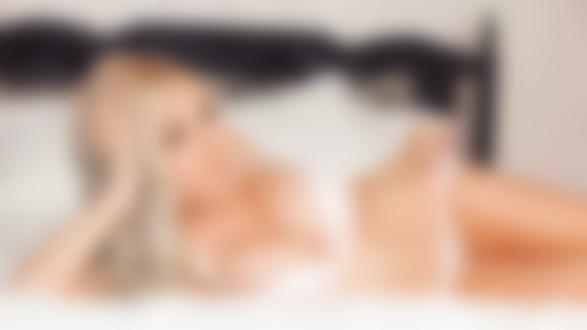 Обои на рабочий стол Сексуальная модель с большой грудью Jessica Nigri лежит на кровати
