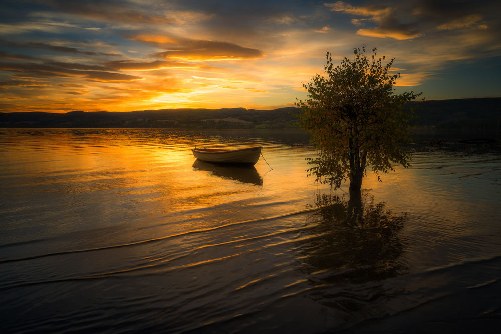 Обои для рабочего стола Лодка на воде на фоне заката. Фотограф Ole Henrik Skjelstad