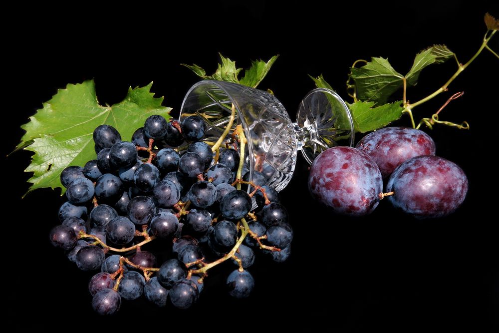 Обои для рабочего стола Натюрморт с темным виноградом, сливами, листьями и вазочкой, темный фон, by Radfotosonn