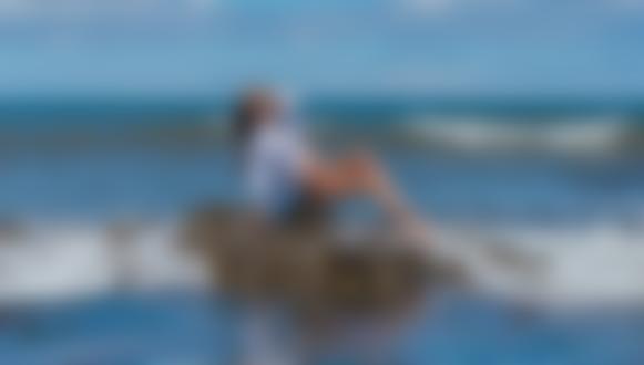 Обои на рабочий стол Девушка в белой рубашке позирует, сидя на рифе в море, фотограф Владимир