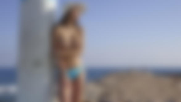Обои на рабочий стол Фотомодель Jessica Albanka в голубых трусиках и летней шляпе облокотилась о бетонный столб на фоне пляжа в солнечный день