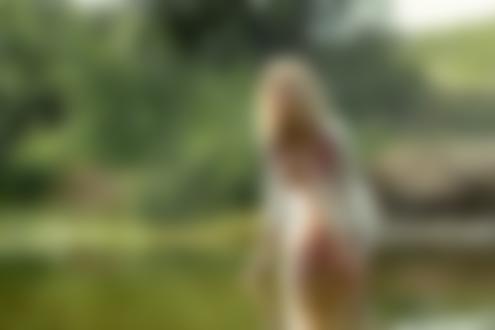 Обои для рабочего стола Полуобнаженная блондинка в расстегнутой рубашке позирует, стоя в водоеме на фоне природы. Фотограф Воронцов Игорь