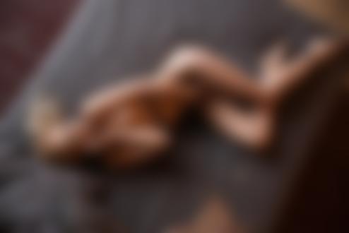 Обои на рабочий стол Обнаженная модель Ольга Сорокина в сетчатых колготках позирует, лежа на постели в помещении. Фотограф Леонид Маркачев