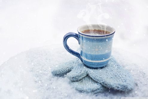 Обои на рабочий стол Чашка горячего кофе стоит на варежках