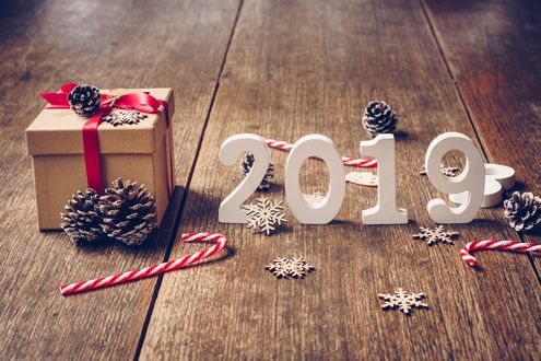 Обои на рабочий стол Цифры 2019 на досках среди шишек, сладостей, снежинок и подарка