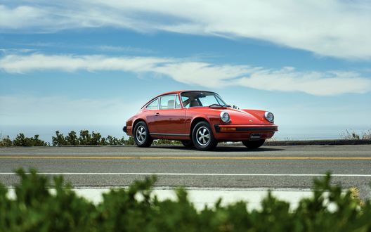 Обои на рабочий стол Красный Porsche 912 E купе припаркованный на дороге на фоне облаков