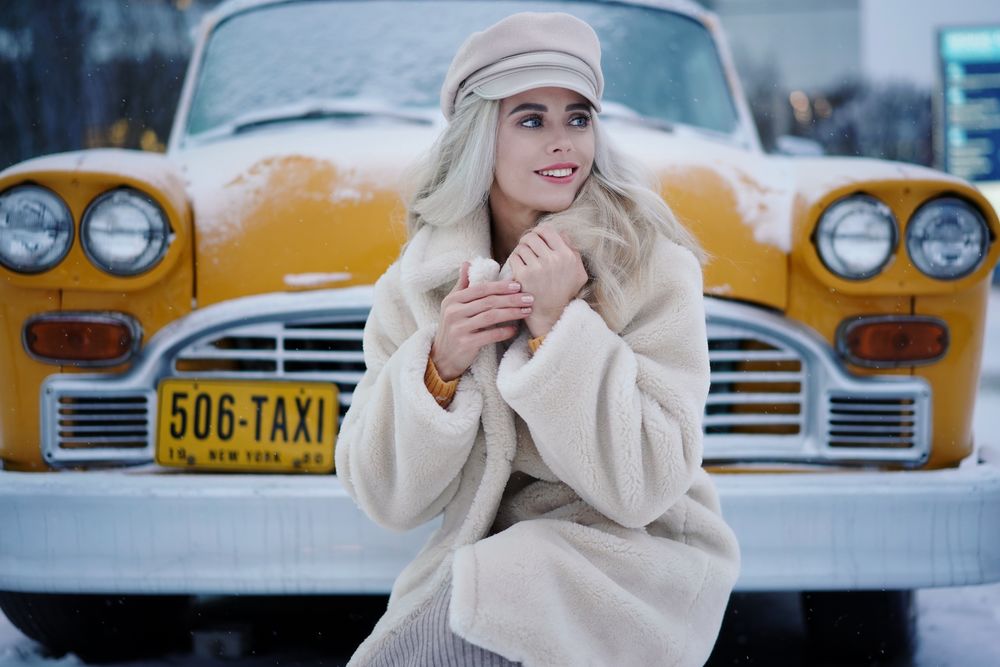 Обои для рабочего стола Улыбающаяся девушка - блондинка стоит у такси, фотограф Sergei Churnosov
