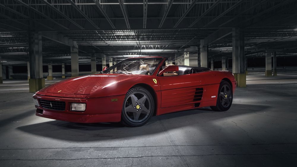 Обои для рабочего стола Кабриолет Ferrari 348 темно-красного цвета на крытой автостоянке ночью