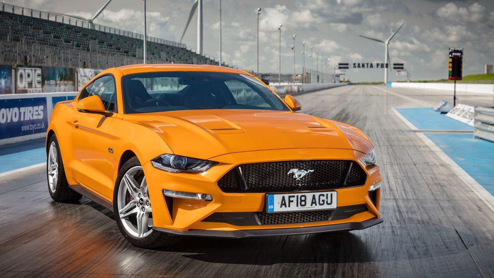 Обои для рабочего стола Оранжевый Ford Mustang GT 2015 на гоночном треке